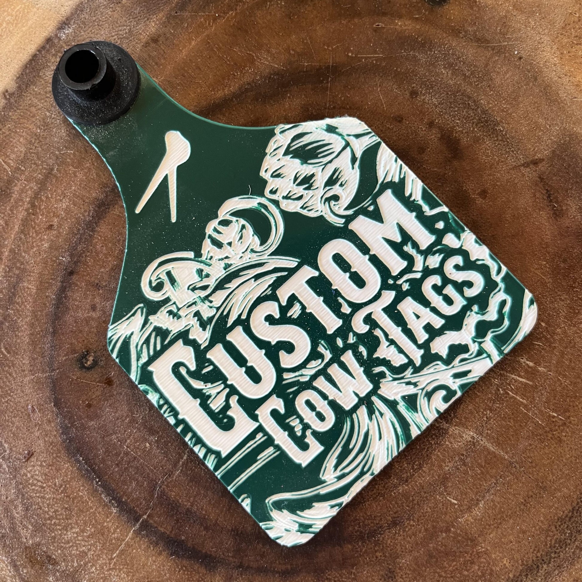 Green and white 'Custom Cow Tags' label on a wooden surface