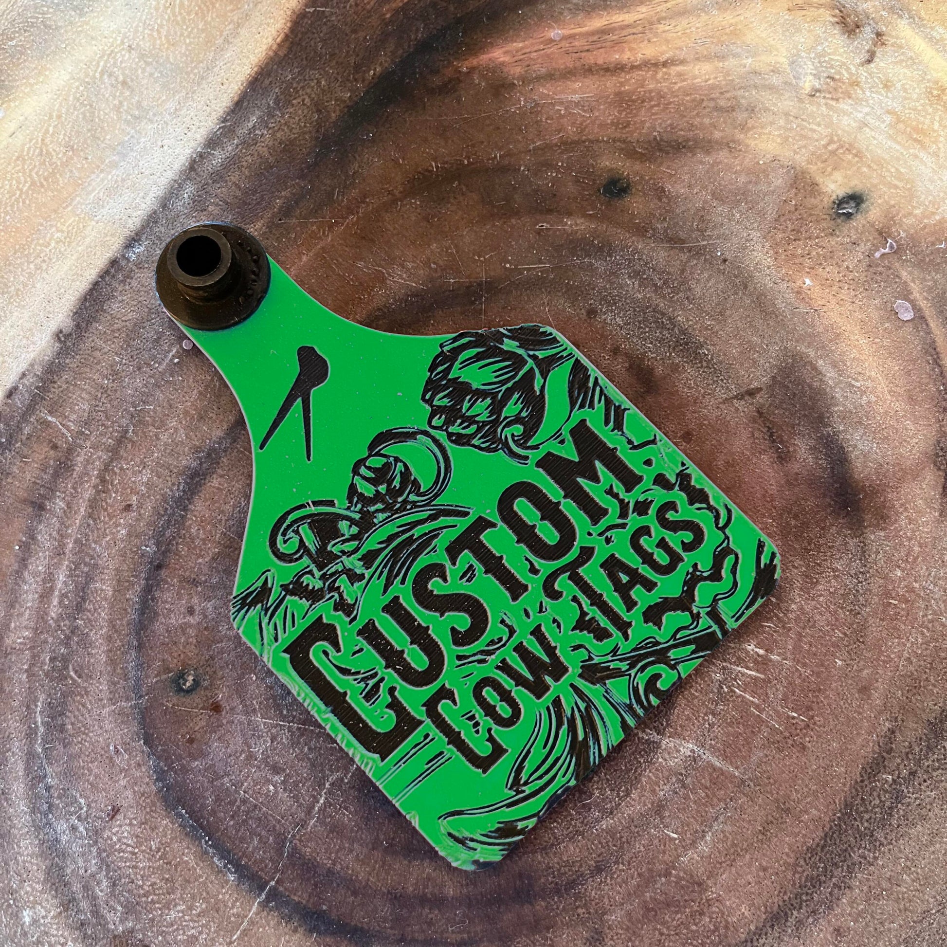 Green and black 'Custom Low Tags' tag on a wooden surface